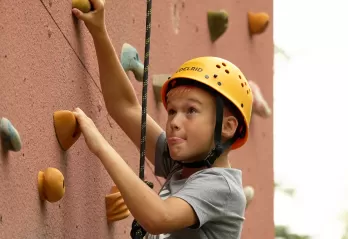 boy climbing wall at camp