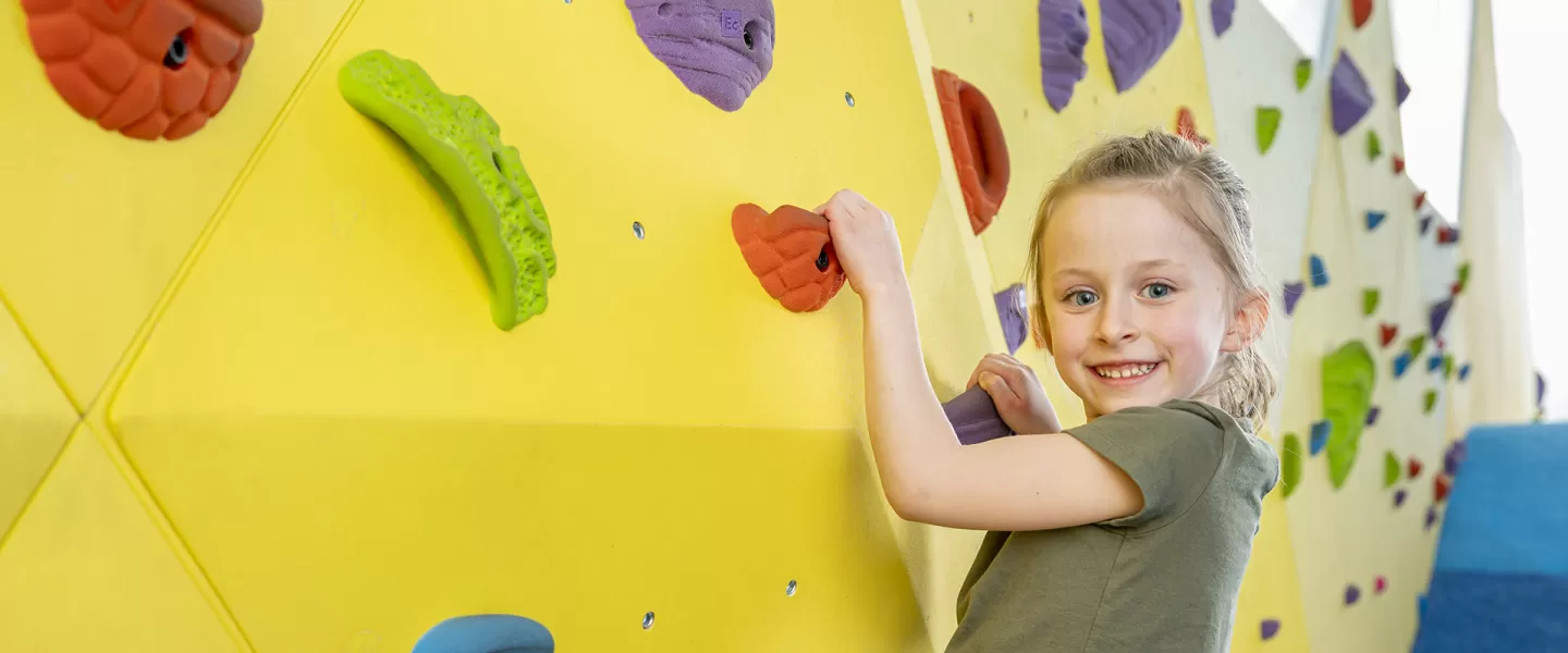 little girl playing on climbing wall