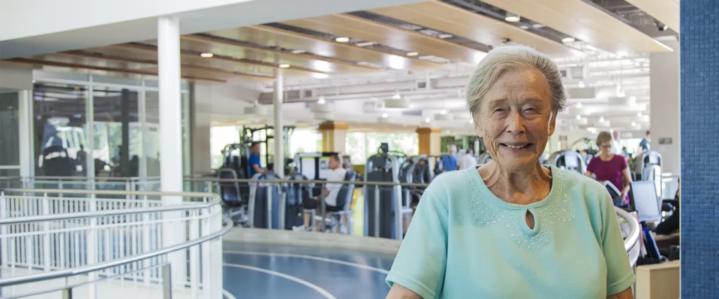 older woman smiling on indoor track