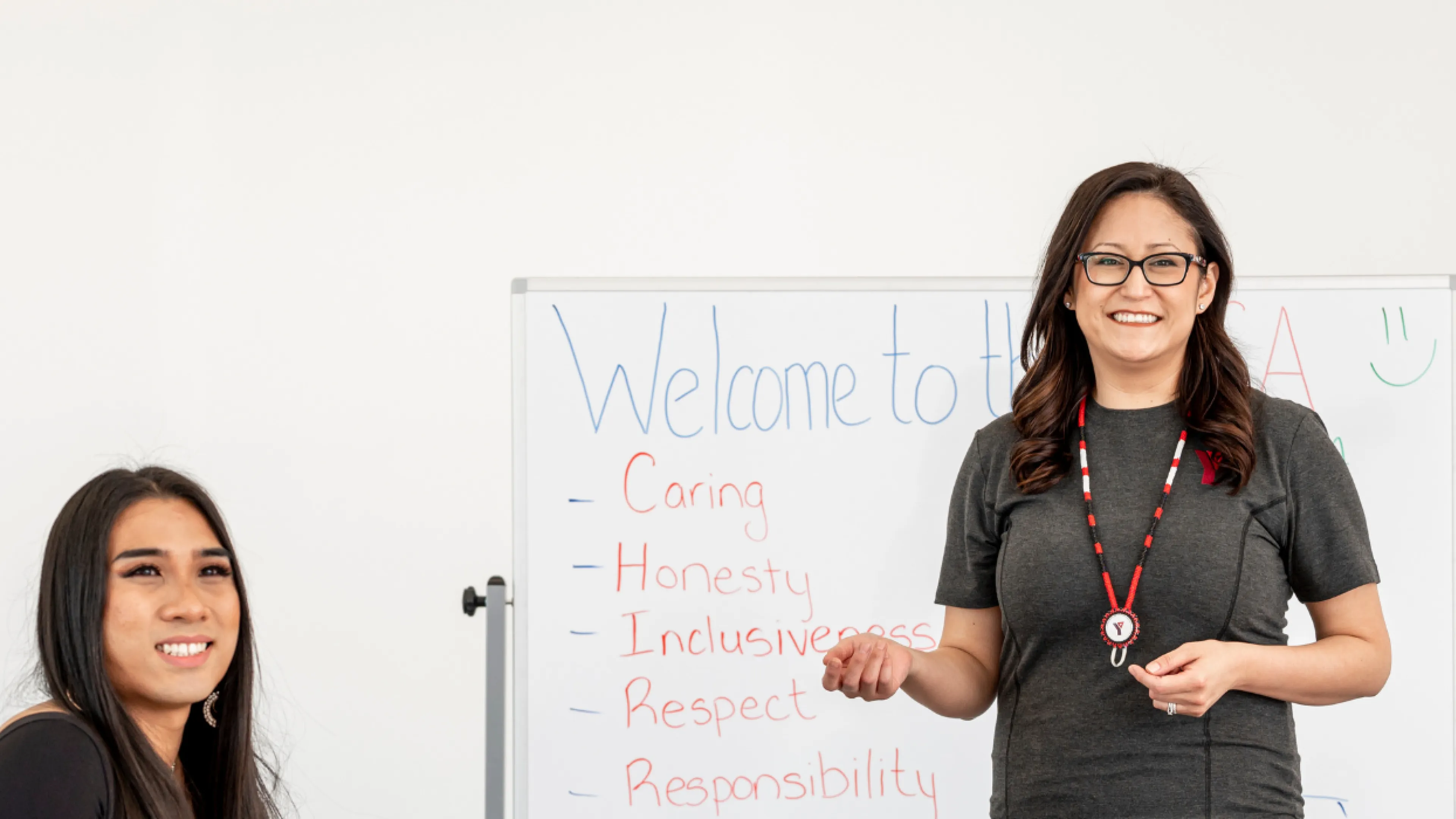 A group of people in a classroom setting, all smiling