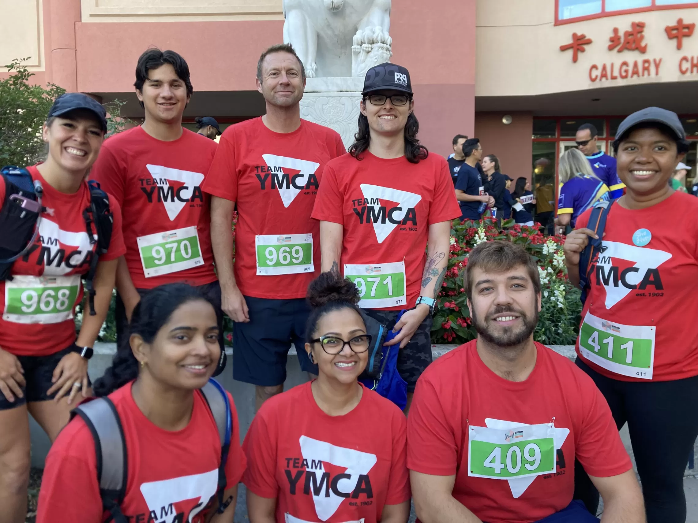 Team YMCA is ready to hit the 5K run, wearing their red YMCA shirts and runner numbers.
