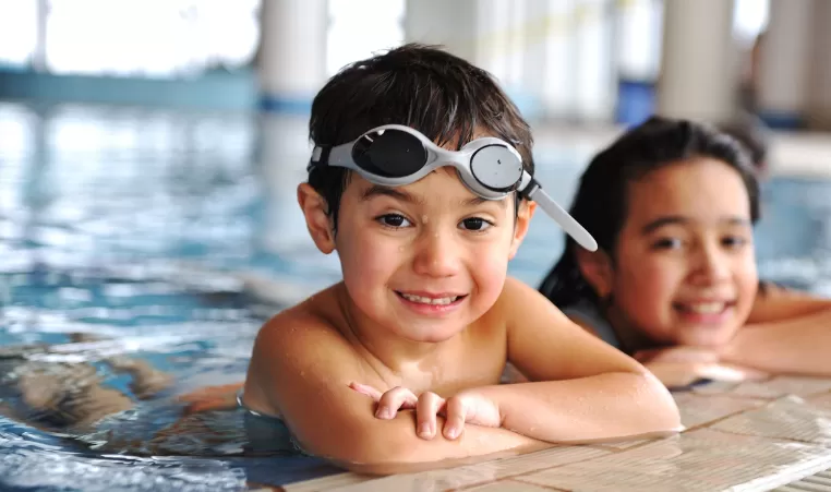 kids floating on the edge of a pool