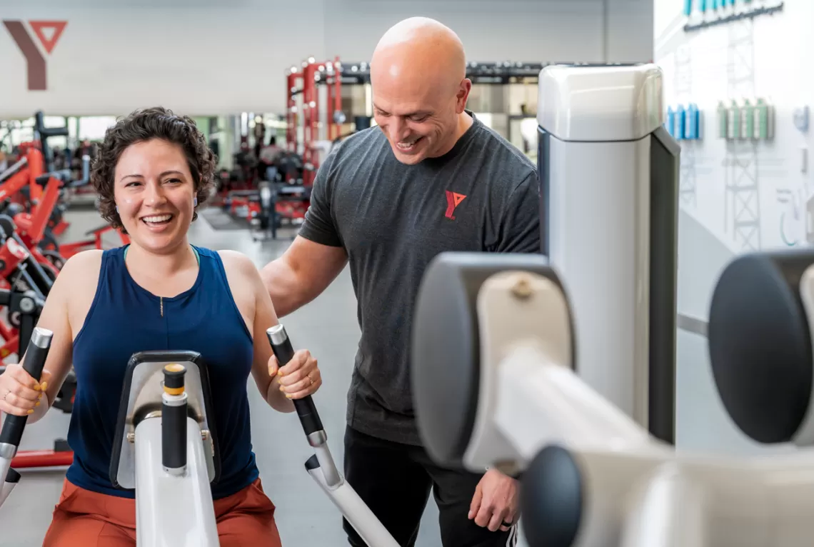 Personalized progression YFit Certified trainer and client on the weight floor