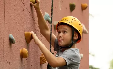 boy climbing wall at camp