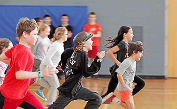 large group of youth running in gym